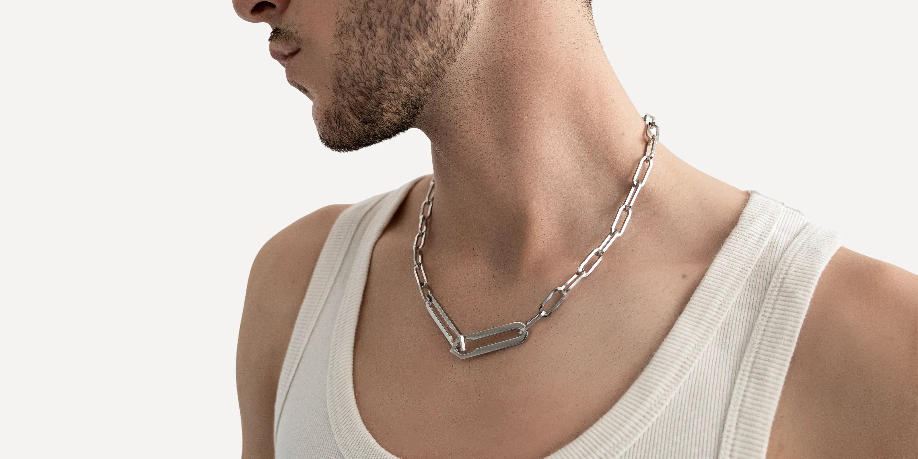 Männliches Model trägt die Forma Nexus Halskette in Silber aus 316L-Edelstahl und setzt das elegante Design stilvoll in Szene.