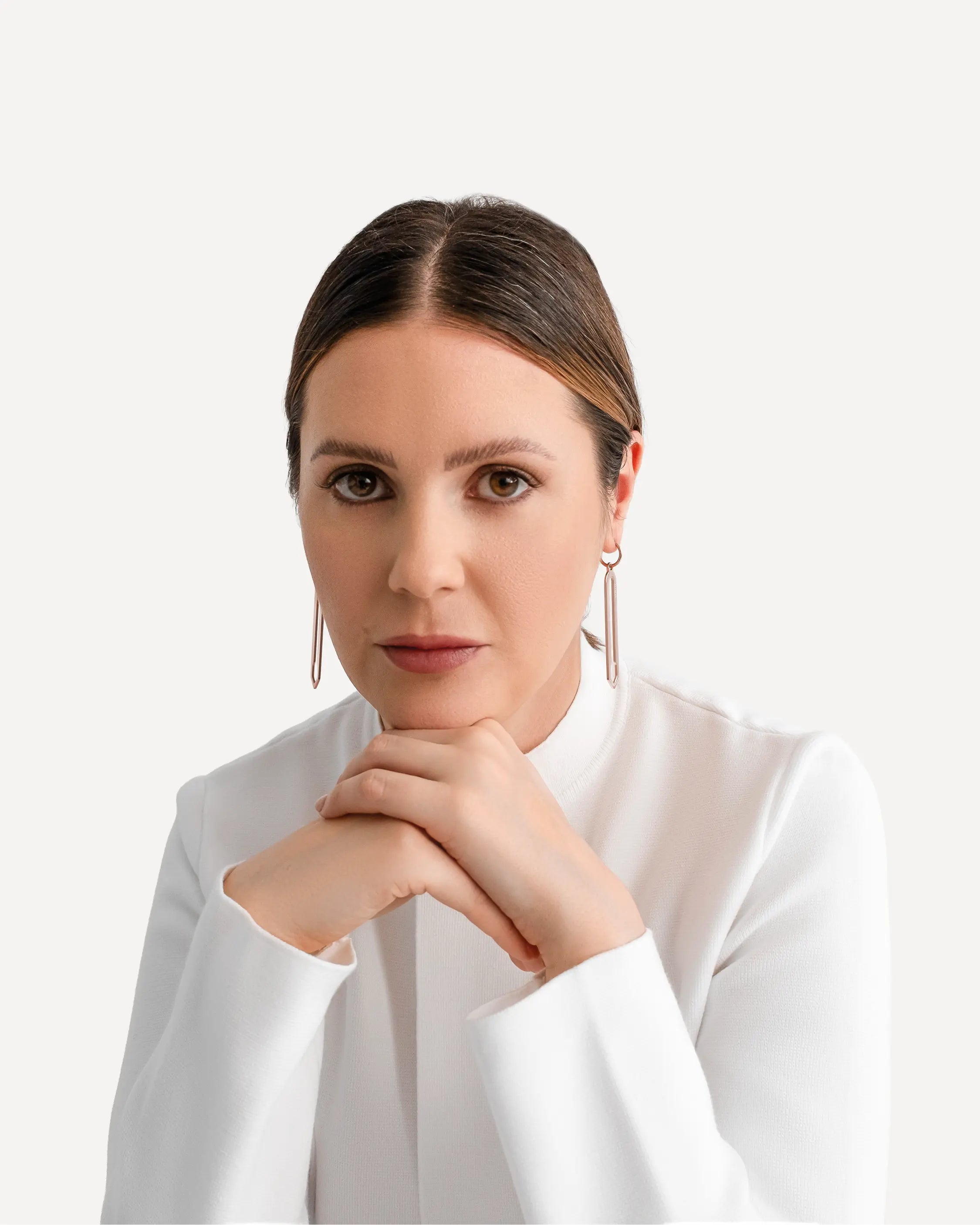 Weibliches Model trägt die Forma Lamina Ohrringe in Roségold aus 316L-Edelstahl und setzt das elegante Design stilvoll in Szene.