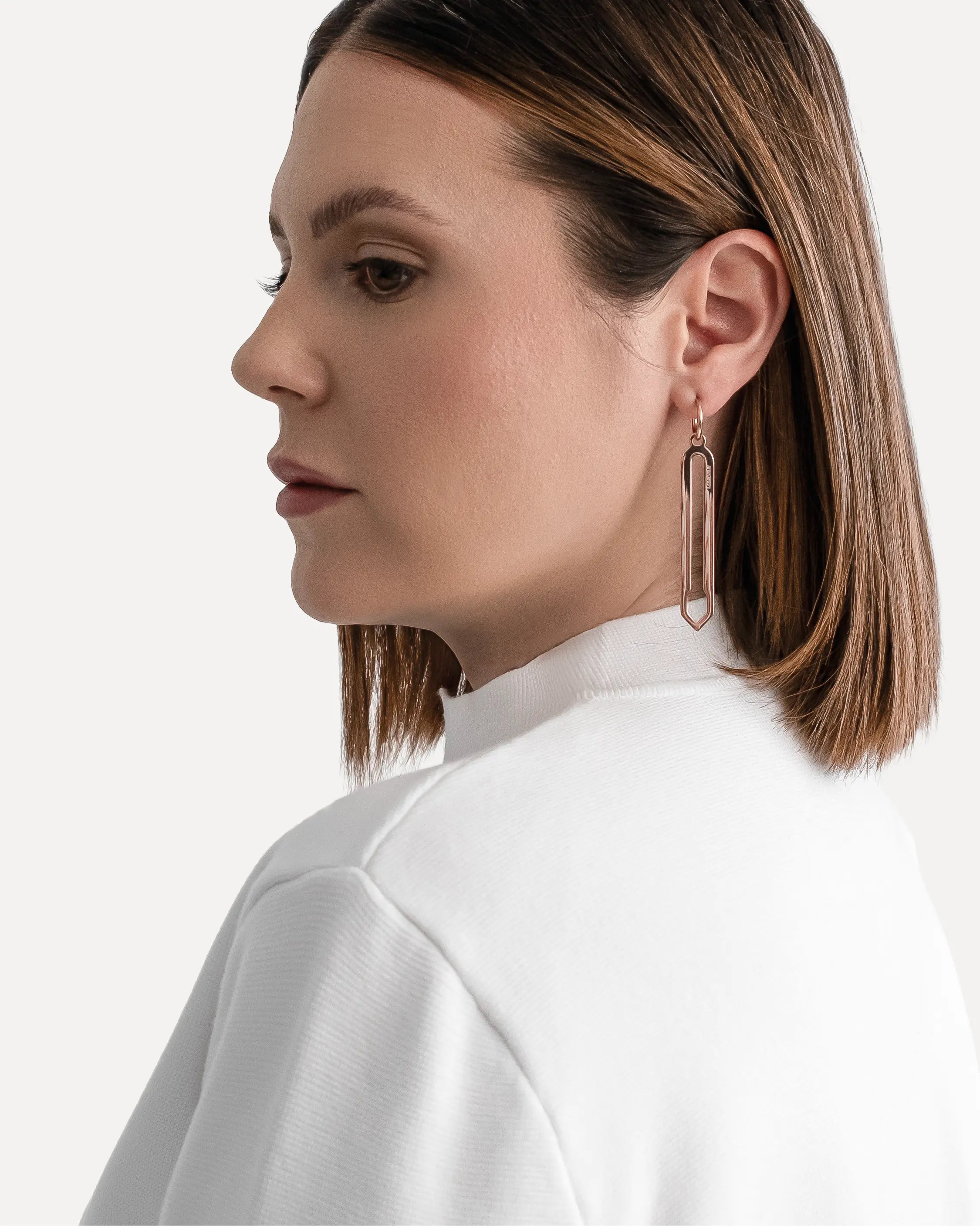 Männliches Model trägt die Forma Lamina Ohrringe in Roségold aus 316L-Edelstahl und setzt das elegante Design stilvoll in Szene.