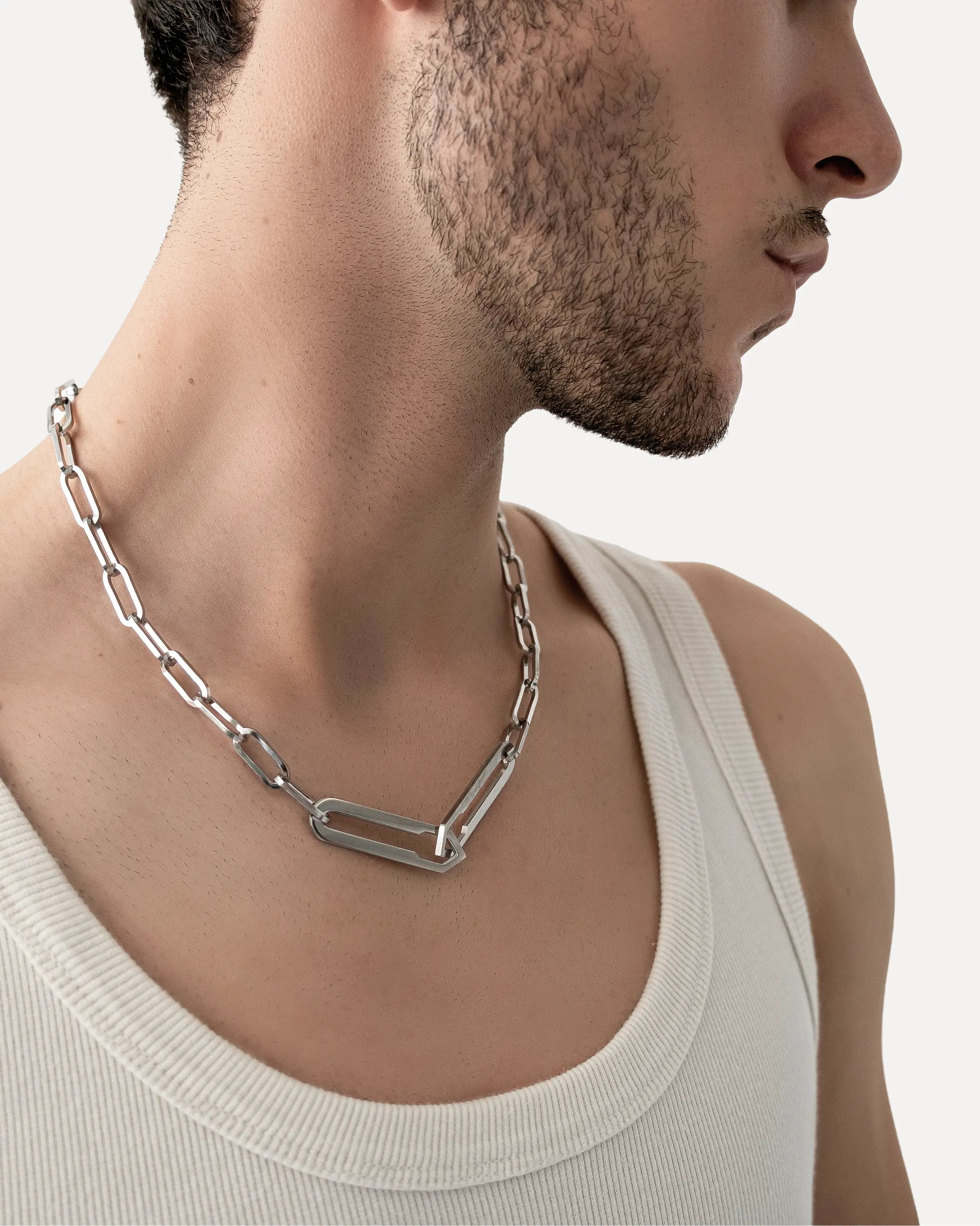 Männliches Model trägt die Forma Nexus Halskette in Silber aus 316L-Edelstahl und setzt das elegante Design stilvoll in Szene.
