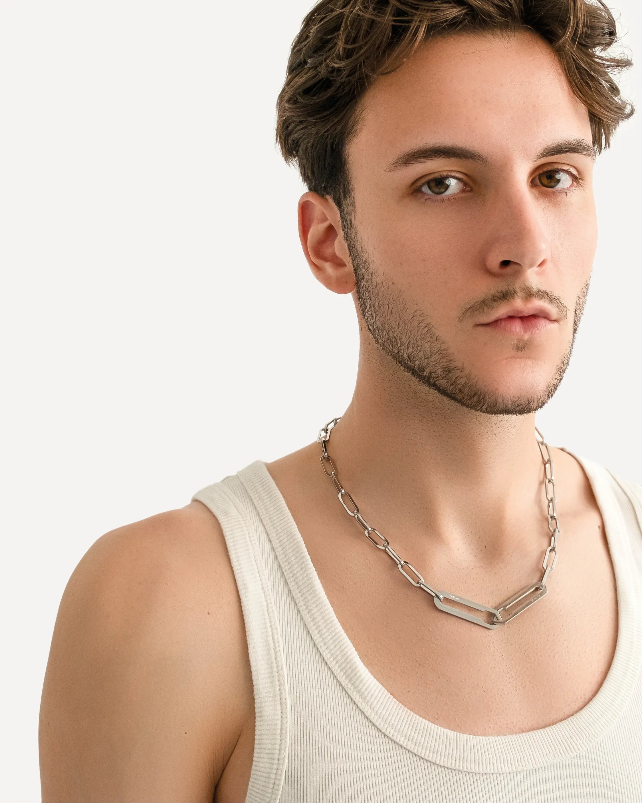 Männliches Model trägt die Forma Nexus Halskette in Silber aus 316L-Edelstahl und setzt das elegante Design stilvoll in Szene.