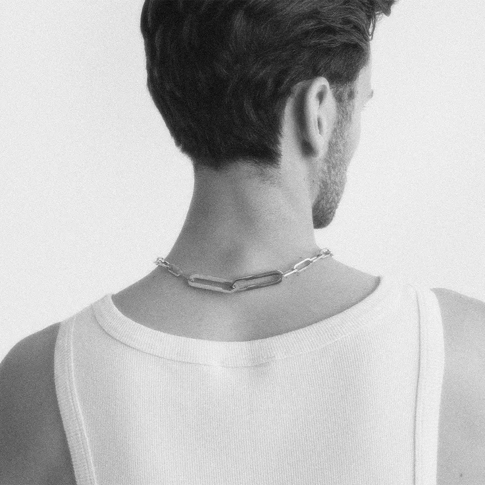 Männliches Model trägt die Forma Nexus Halskette in Silber aus 316L-Edelstahl und setzt das elegante Design stilvoll in Szene.