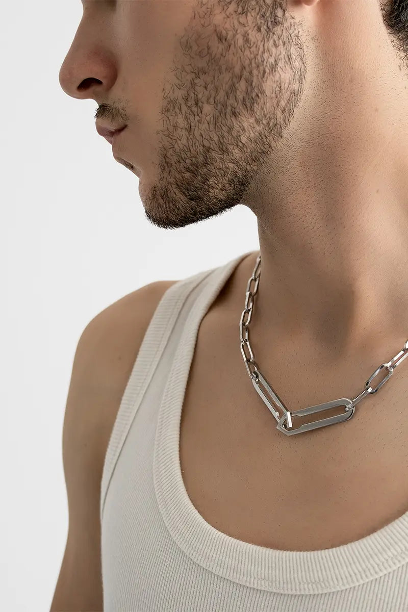 Männliches Model trägt die Forma Infini Halskette in Silber aus 316L-Edelstahl und setzt das elegante Design stilvoll in Szene.