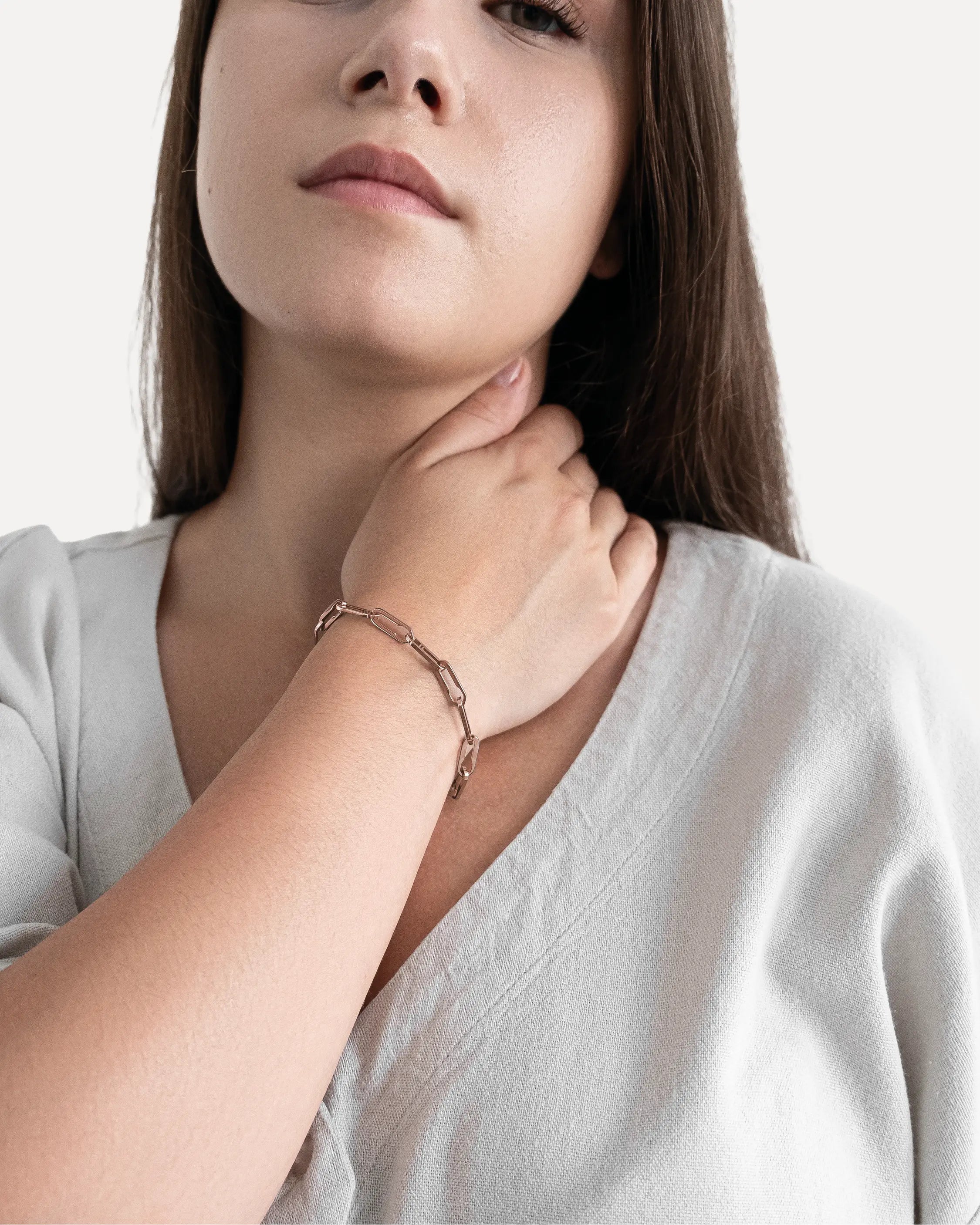 Weibliches Model trägt das Forma Aeterna Armband in Roségold aus 316L-Edelstahl und setzt das elegante Design stilvoll in Szene.