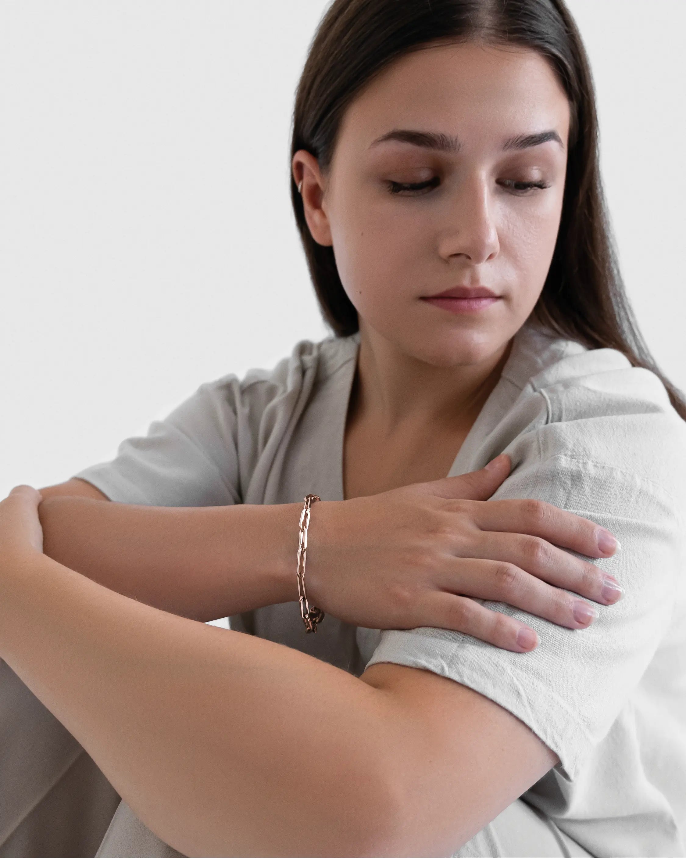 Weibliches Model trägt das Forma Infini Armband in Roségold aus 316L-Edelstahl und setzt das elegante Design stilvoll in Szene.