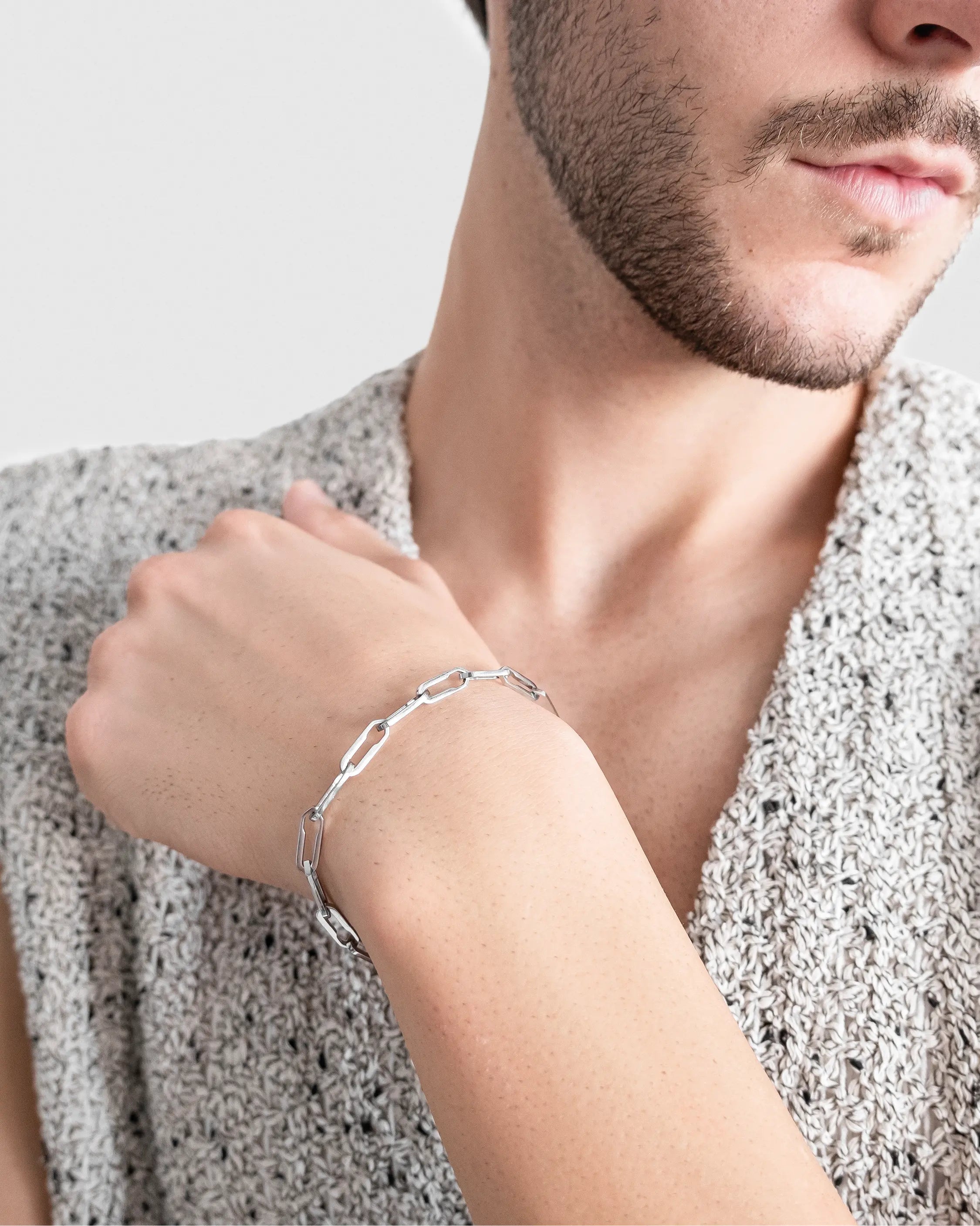Männliches Model trägt das Forma Infini Armband in Silber aus 316L-Edelstahl und setzt das elegante Design stilvoll in Szene.