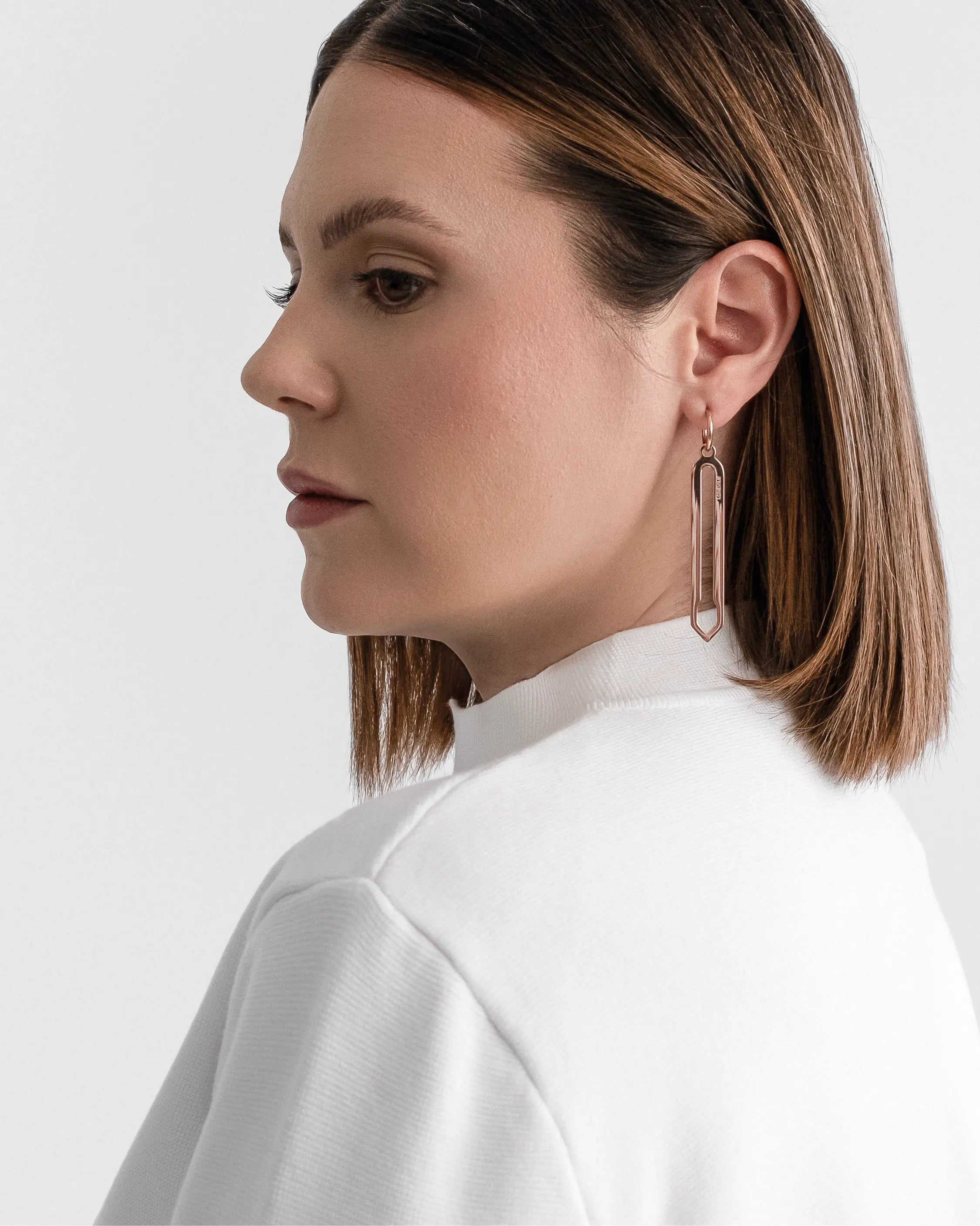 Männliches Model trägt die Forma Lamea Ohrringe in Roségold aus 316L-Edelstahl und setzt das elegante Design stilvoll in Szene.