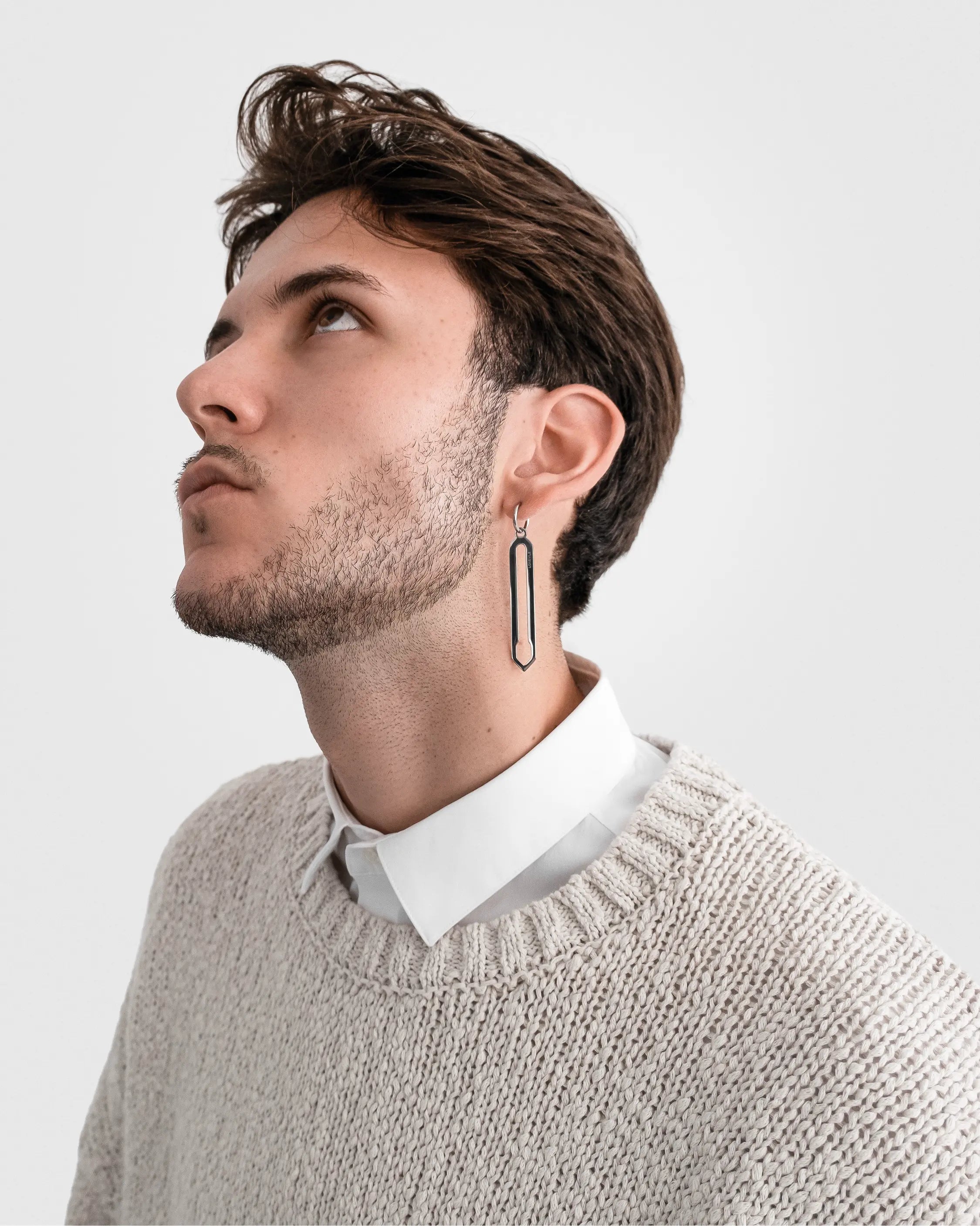Männliches Model trägt die Forma Lamea Ohrringe in Silber aus 316L-Edelstahl und setzt das elegante Design stilvoll in Szene.