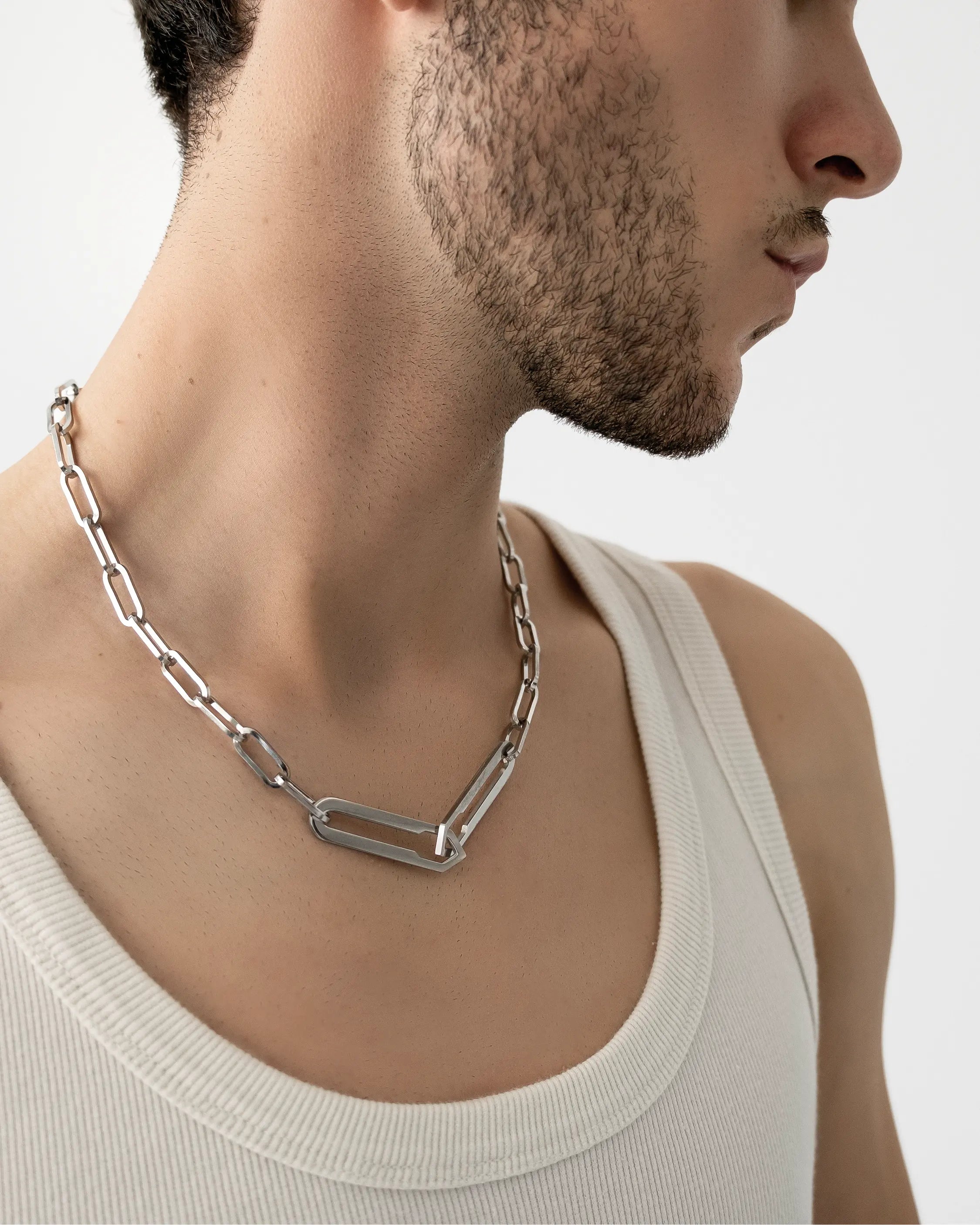 Männliches Model trägt die Forma Infini Halskette in Silber aus 316L-Edelstahl und setzt das elegante Design stilvoll in Szene.