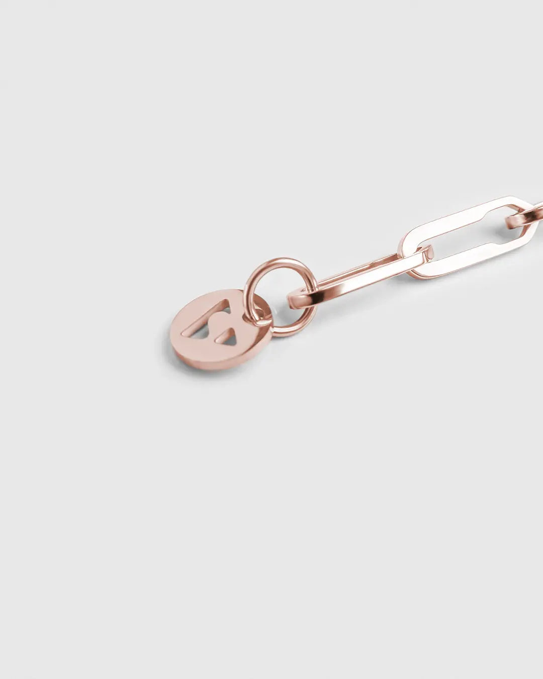 Roségoldenes Forma Infini Armband aus 316L-Edelstahl, Nahaufnahme des eleganten Logo Anhängers.